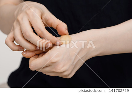準備進行姜灸療法時,將生薑放在女性的手背上。 準備進行姜灸療法時,將生薑放在女性的手背上。 141782729