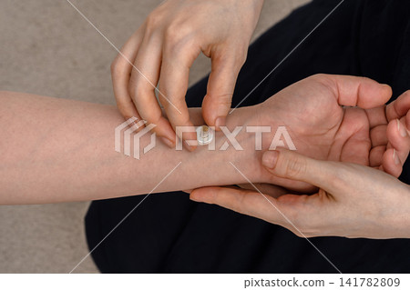 一位女針灸師正在調整病人手腕上的艾灸底座。 141782809