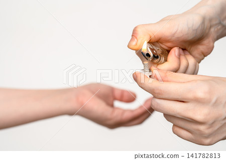 A female acupuncturist lights the moxa cone with a lighter before treatment. 141782813