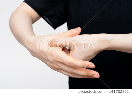 按壓女性上身手背上的穴位 按壓女性上身手背上的穴位 141782851