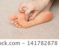 A woman's feet and toes, with smoke rising from a moxibustion device on the soles of her feet. 141782878