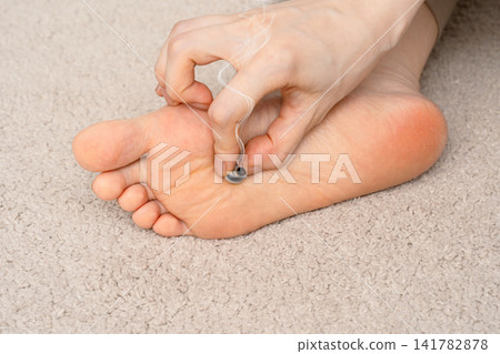 A woman's feet and toes, with smoke rising from a moxibustion device on the soles of her feet. 141782878