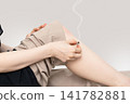 A burning moxibustion pedestal and both hands near the knee of a bent woman. 141782881