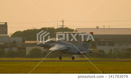 A Japan Air Self-Defense Force T-4 trainer aircraft takes off at dusk. 141783079