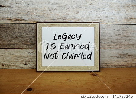 Legacy Is Earned Not Claimed text written in horizontal frame standing on wooden surface Legacy Is Earned Not Claimed text written in horizontal frame standing on wooden surface 141783240