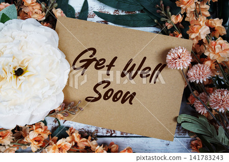 Get Well Soon text with flowers decorations on wooden background Get Well Soon text with flowers decorations on wooden background 141783243