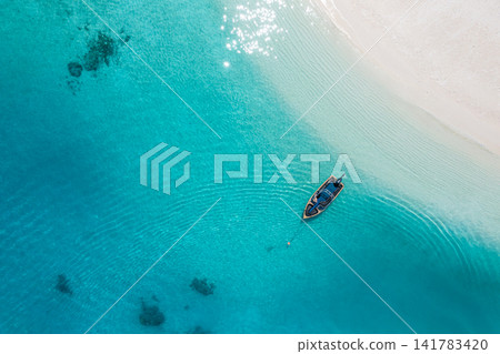 Luminous overhead ocean lone boat drifting over turquoise lagoon powdery sandbank tropical crystal clear water. Perfect summer travel seascape paradise. Calm outdoors wellness copy space scenic Luminous overhead ocean lone boat drifting over turquoise lagoon powdery sandbank tropical crystal clear water. Perfect summer travel seascape paradise. Calm outdoors wellness copy space scenic 141783420