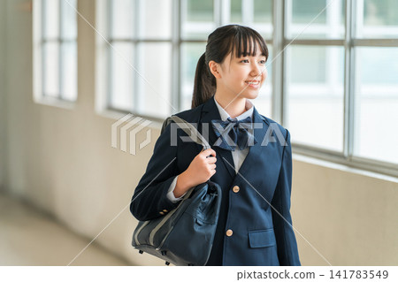 Female students, elementary school students, junior high school students, and high school students in uniform walking down a school corridor Female students, elementary school students, junior high school students, and high school students in uniform walking down a school corridor 141783549