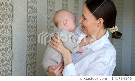 Young mother happily embracing newborn baby, showing Young mother happily embracing newborn baby, showing 141784146