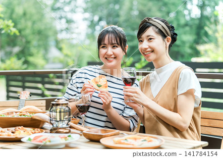 Young women enjoying meals on the terrace, barbecues, home parties, and glamping with friends. Young women enjoying meals on the terrace, barbecues, home parties, and glamping with friends. 141784154