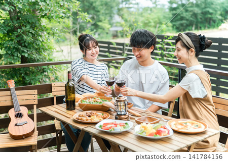 年輕的亞洲男女、朋友、同事和同事在木甲板上燒烤、家庭聚會和豪華露營 141784156