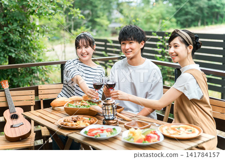 年輕的亞洲男女、朋友、同事和同事在木甲板上燒烤、家庭聚會和豪華露營 141784157