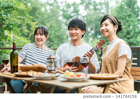 Young Asian men and women, friends, companions, colleagues having a barbecue, home party, glamping on a wooden deck Young Asian men and women, friends, companions, colleagues having a barbecue, home party, glamping on a wooden deck 141784158