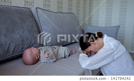 Postpartum mother feeling exhausted and overwhelmed with newborn Postpartum mother feeling exhausted and overwhelmed with newborn 141784242