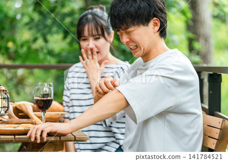 一對夫婦在戶外用餐時飽受昆蟲叮咬之苦。 141784521