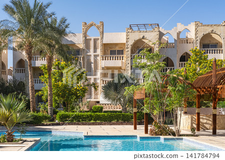 Luxury tropical resort swimming pool and garden landscaping. Modern architecture with tropical palms Luxury tropical resort swimming pool and garden landscaping. Modern architecture with tropical palms 141784794