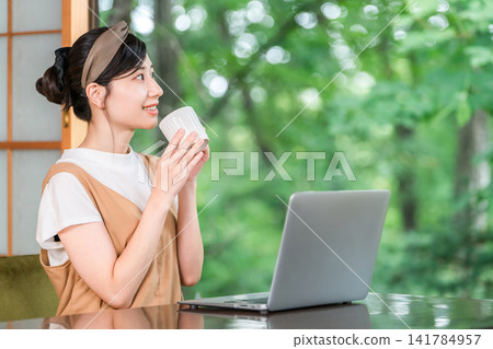 Workation, taking a break to work at a destination, a woman taking a rest (having tea, drinking) Workation, taking a break to work at a destination, a woman taking a rest (having tea, drinking) 141784957