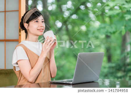 Workation, taking a break to work at a destination, a woman taking a rest (having tea, drinking) Workation, taking a break to work at a destination, a woman taking a rest (having tea, drinking) 141784958