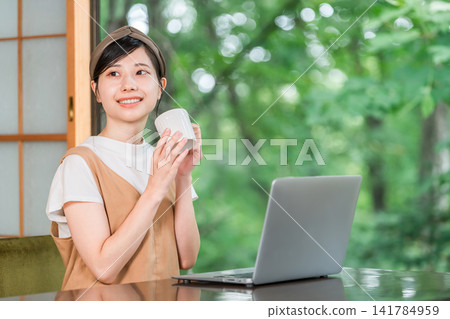 Workation, taking a break to work at a destination, a woman taking a rest (having tea, drinking) Workation, taking a break to work at a destination, a woman taking a rest (having tea, drinking) 141784959