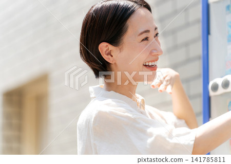 一位女士正在自動販賣機購買飲料。 一位女士正在自動販賣機購買飲料。 141785811