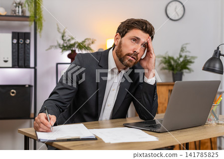 Middle-aged businessman lawyer reviews contracts finds mistake facepalm then corrects with pen fast Middle-aged businessman lawyer reviews contracts finds mistake facepalm then corrects with pen fast 141785825