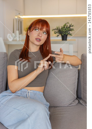Young woman counts tasks on fingers folds digits tallies list with focus and nods thoughtful rhythm Young woman counts tasks on fingers folds digits tallies list with focus and nods thoughtful rhythm 141785853