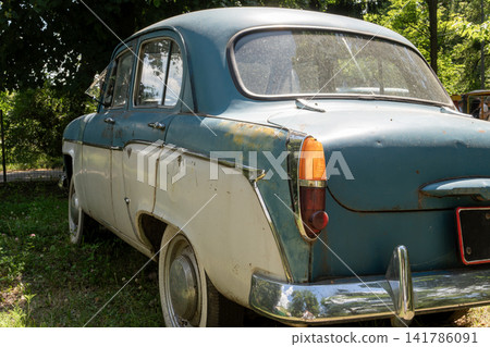 Rear Angle View of Two Tone Vintage Soviet Sedan Parked Outdoors Rear Angle View of Two Tone Vintage Soviet Sedan Parked Outdoors 141786091
