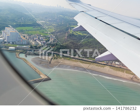 Airplane wing view over Tokyo coastline and sea in Japan 141786232