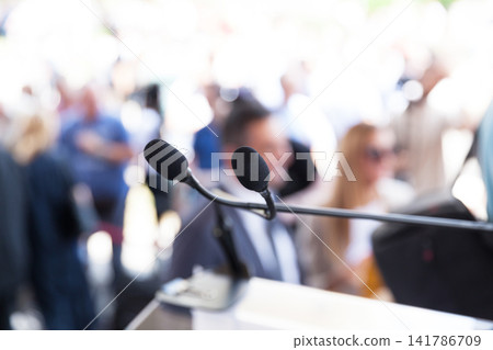 Microphone in focus at media or public event, blurred people in the background Microphone in focus at media or public event, blurred people in the background 141786709