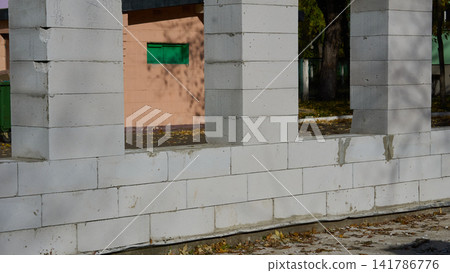 Construction site.House wall under construction with window openings Construction site.House wall under construction with window openings 141786776