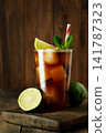 Refreshing cuba libre cocktail with cola, rum, lime, and mint, cold drink featuring ice cubes on rustic wooden table 141787323