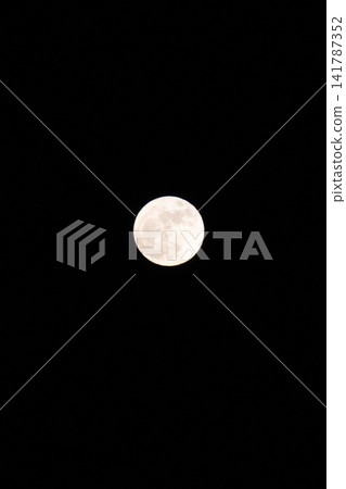 一輪明亮的滿月懸掛在漆黑的夜空中。 一輪明亮的滿月懸掛在漆黑的夜空中。 141787352