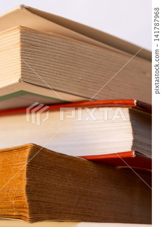 A stack of books arranged in a pile. The books vary in size and color, with visible spines and covers. Some have bookmarks protruding from them. A stack of books arranged in a pile. The books vary in size and color, with visible spines and covers. Some have bookmarks protruding from them. 141787968