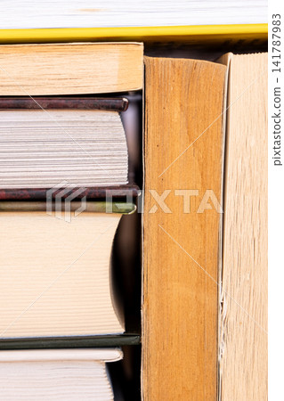 A close-up view of a stack of books in various colors and sizes. The books are arranged neatly, showcasing their spines and covers. A close-up view of a stack of books in various colors and sizes. The books are arranged neatly, showcasing their spines and covers. 141787983