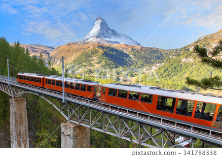 Zermatt, Switzerland. Gornergrat red tourist train and Matterhorn peak panorama in Swiss Alps Zermatt, Switzerland. Gornergrat red tourist train and Matterhorn peak panorama in Swiss Alps 141788338