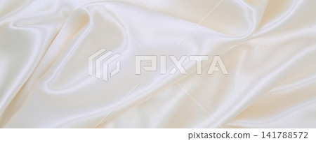 Smooth elegant white silk or satin luxury cloth texture as wedding background. Luxurious Christmas background or New Year background design Smooth elegant white silk or satin luxury cloth texture as wedding background. Luxurious Christmas background or New Year background design 141788572