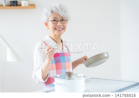 一位老婦人正在做飯 141788818