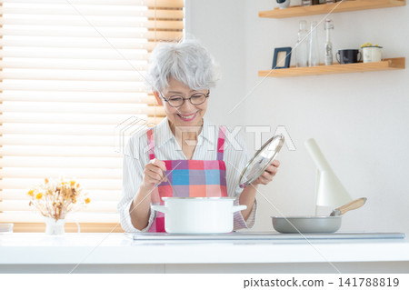 一位老婦人正在做飯 141788819