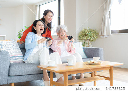 A senior female friend playing games in the living room A senior female friend playing games in the living room 141788825