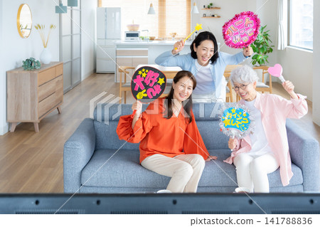 A senior female friend who engages in her fan activities in the living room. A senior female friend who engages in her fan activities in the living room. 141788836