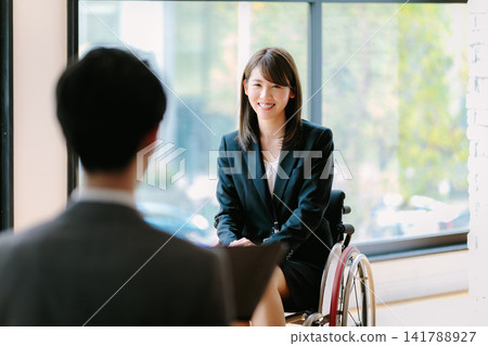 Job interview for disabled employment: Woman in a wheelchair Job interview for disabled employment: Woman in a wheelchair 141788927