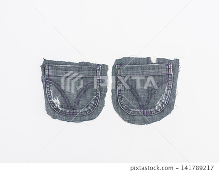 Two separate blue denim pockets with purple stitching, isolated on white Two separate blue denim pockets with purple stitching, isolated on white 141789217