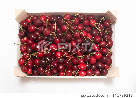 Top view of a wooden crate full of fresh, ripe, sweet summer cherries on white Top view of a wooden crate full of fresh, ripe, sweet summer cherries on white 141789218
