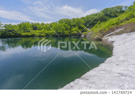 A spectacular early summer scene of Ezo Marsh in the Daisetsuzan Mountains of Hokkaido, adorned with lingering snow. A spectacular early summer scene of Ezo Marsh in the Daisetsuzan Mountains of Hokkaido, adorned with lingering snow. 141789724