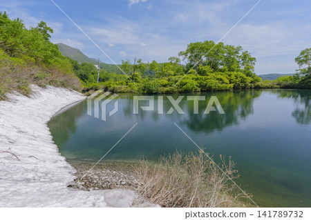 A spectacular early summer scene of Ezo Marsh in the Daisetsuzan Mountains of Hokkaido, adorned with lingering snow. A spectacular early summer scene of Ezo Marsh in the Daisetsuzan Mountains of Hokkaido, adorned with lingering snow. 141789732