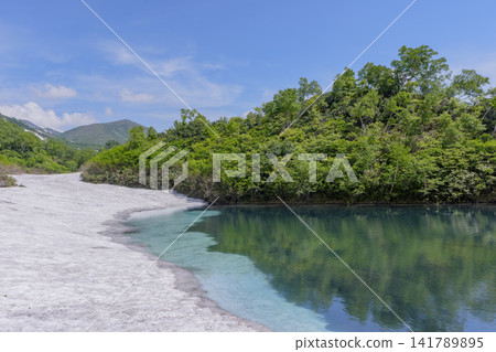 Hokkaido's Daisetsuzan: A breathtaking early summer scene of Shikibu Pond in the Daisetsuzan Plateau marshland and lingering snow. Hokkaido's Daisetsuzan: A breathtaking early summer scene of Shikibu Pond in the Daisetsuzan Plateau marshland and lingering snow. 141789895