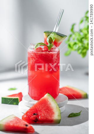 A watermelon lemonade or mojito with ice and basil in a glass on a gray background 141789990