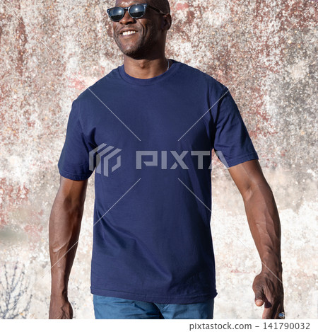 Blank dark blue t-shirt mockup on smiling black man outdoors, front view with copy space 141790032