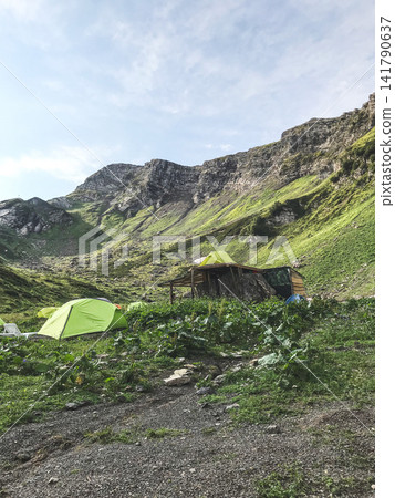 Mountain campsite in alpine valley Mountain campsite in alpine valley 141790637