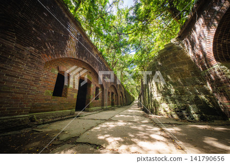 The brick fortress ruins and sunlight filtering through the trees at the site of the Third Battery on Tomogashima Island The brick fortress ruins and sunlight filtering through the trees at the site of the Third Battery on Tomogashima Island 141790656